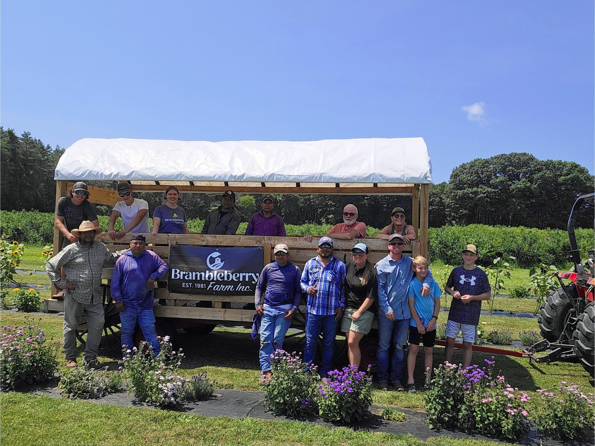photo of the Brambleberry farm team in front of a farmstand